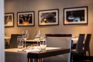 a table in a restaurant with wine glasses on it at Hilton Strasbourg in Strasbourg