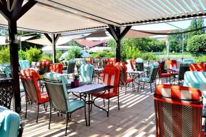 a patio with tables and chairs under a roof at Hilton Strasbourg in Strasbourg