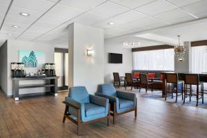 a waiting room with blue chairs and a table at Hampton Inn Philadelphia/King of Prussia - Valley Forge in King of Prussia