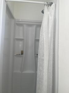 a white shower curtain is hanging in a bathroom at Town House Motel in Sanger