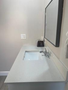 a white sink in a bathroom with a mirror at Town House Motel in Sanger