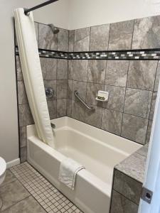 a bathroom with a tub and a toilet at Town House Motel in Sanger