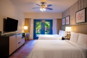 a hotel room with two beds and a flat screen tv at Cliffrose Springdale, Curio Collection By Hilton in Springdale