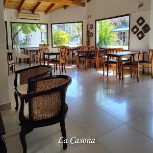 um restaurante com mesas, cadeiras e janelas em La Casona em Federación