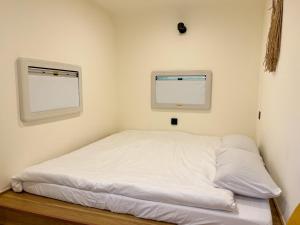 Bett in einem Zimmer mit 2 Fenstern in der Unterkunft 水旅居露營車 in Toucheng