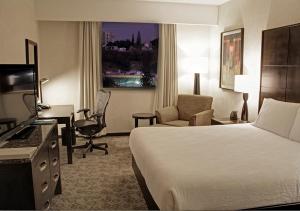 a hotel room with a bed and a desk and chair at Hilton Garden Inn Tuxtla Gutierrez in Tuxtla Gutiérrez