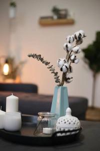 a blue vase with flowers in it on a table at Stylish & Renovated Modern Farmhouse Boutique Apt in Gainesville