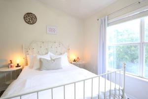 a bedroom with a white bed and a large window at Stylish & Renovated Modern Farmhouse Boutique Apt in Gainesville