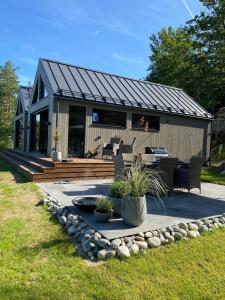 een tiny house met een terras en een patio bij Perle ved sjøen! Ny hytte på 90m2. in Kragerø