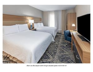 een hotelkamer met 2 bedden en een flatscreen-tv bij Candlewood Suites DFW Airport North - Irving, an IHG Hotel in Irving