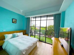 a bedroom with a bed and a large window at 35.5 Inn in Kenting