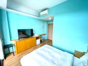 a hotel room with a bed and a flat screen tv at 35.5 Inn in Kenting