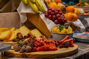 una tabla de cortar llena de diferentes tipos de frutas y hortalizas en Wine & Books Lisboa Hotel, en Lisboa