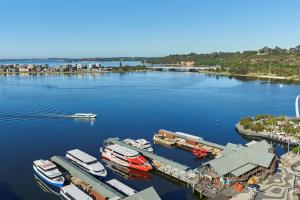 珀斯Doubletree By Hilton Perth Waterfront的享有码头的空中景色,在水中划船