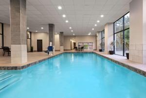 een groot zwembad met blauw water in een gebouw bij Embassy Suites by Hilton Dallas-Love Field in Dallas