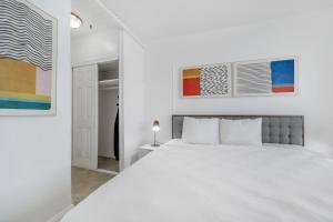 a white bedroom with a large bed and a mirror at Starlite Hotel in Miami Beach