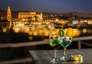 dos copas de vino en una mesa con vistas a la ciudad en Hesperia Córdoba, en Córdoba