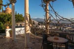 d'une terrasse avec une table et des chaises et une vue sur la ville. dans l'établissement Carmen de la Alcubilla del Caracol, à Grenade