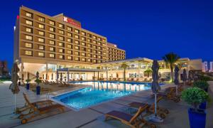 un hôtel avec une piscine en face d'un bâtiment dans l'établissement Hilton Garden Inn Ras Al Khaimah, à Ras al Khaimah