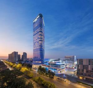 een hoog gebouw in een stad 's nachts bij Doubletree by Hilton Foshan Nanhai-Free Canton Fair Shuttle Bus in Foshan