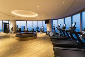 een fitnessruimte met cardio-apparatuur in een gebouw met ramen bij Doubletree by Hilton Foshan Nanhai-Free Canton Fair Shuttle Bus in Foshan