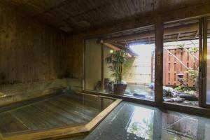 an empty pool in a room with a large window at Toushinan Komeya in Ito