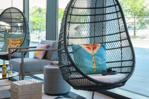 a hanging chair with a pillow in a room at Moxy Lisboa Oriente in Lisbon