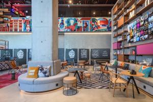 a restaurant with tables and chairs in a room at Moxy Lisboa Oriente in Lisbon