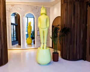 uma grande estátua amarela numa sala com espelhos em art'otel London Battersea Power Station, Powered by Radisson Hotels em Londres