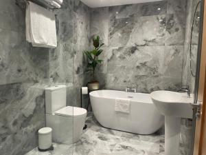 a bathroom with a tub and a sink and a toilet at The Green Inn in Goole