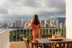 a woman standing on a balcony overlooking a city at Lotus Honolulu at Diamond Head in Honolulu