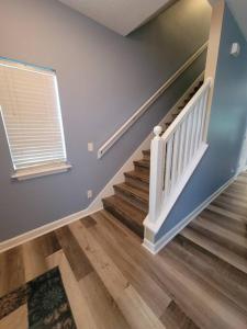 a staircase in a home with blue walls and wooden floors at McDrifty's Getaway in Panama City Beach