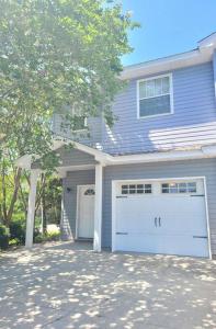 a blue house with a garage and a tree at McDrifty's Getaway in Panama City Beach