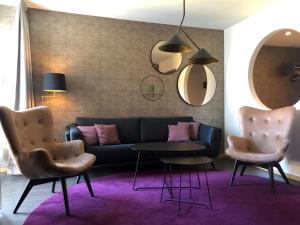 een woonkamer met een bank, 2 stoelen en een tafel bij Hotel Birger Jarl in Stockholm