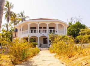 una casa blanca con un camino que conduce a ella en Sand and Shells Beach House- 4 Bedroom with a pool, en Mombasa