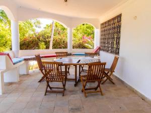 comedor con mesa y sillas en Sand and Shells Beach House- 4 Bedroom with a pool, en Mombasa