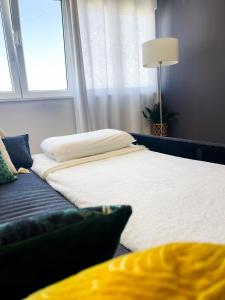 a bed and a couch in a room with a window at Airport Lisbon Guest House in Lisbon