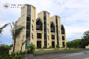 a building on a street with a palm tree at The South-Sunset in Hengchun South Gate