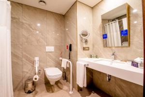 uma casa de banho com um lavatório, um WC e um espelho. em Doubletree By Hilton Antalya City Centre em Antália