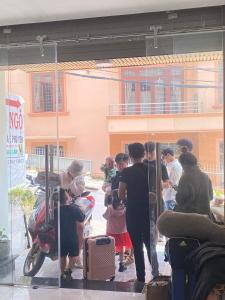 un groupe de personnes debout à l'extérieur d'un bâtiment dans l'établissement Bơ House hotel, à Đà Lạt