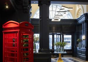 a red telephone booth in a room with a window at The Dilly in London