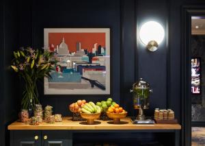 a table with bowls of fruit and a blender on it at The Dilly in London