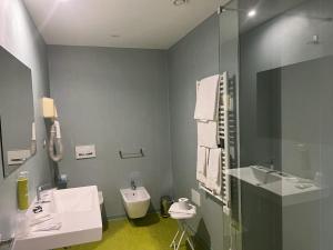 a bathroom with a sink and a toilet and a mirror at Grand Hotel Lamezia in Lamezia Terme