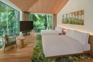 een slaapkamer met een groot wit bed en een flatscreen-tv bij Shisui, a Luxury Collection Hotel, Nara in Nara