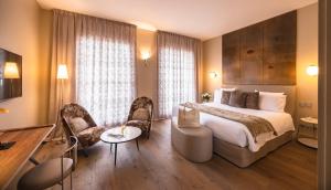 a hotel room with a bed and a table and chairs at Hotel & Spa REGENT PETITE FRANCE in Strasbourg