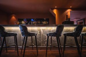 a bar with four chairs in front of a counter at Hotel & Spa REGENT PETITE FRANCE in Strasbourg