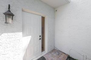 a white door in a white wall with a lamp at Villa at St James Unit A Luxury Pool Villa, Pet Friendly in Miami