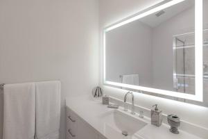 a white bathroom with a sink and a mirror at Villa at St James Unit A Luxury Pool Villa, Pet Friendly in Miami