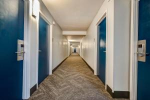 a corridor of a hallway with blue doors at Motel 6 Arlington TX Entertainment District in Arlington