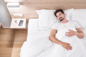 a man is sleeping in a bed at Moov Hotel Lisboa Oriente in Lisbon